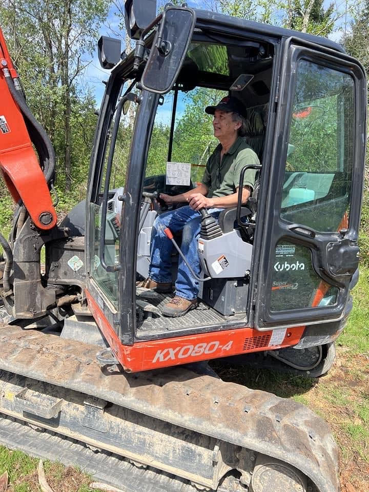 Hong at the controls of an excavator on a job site
